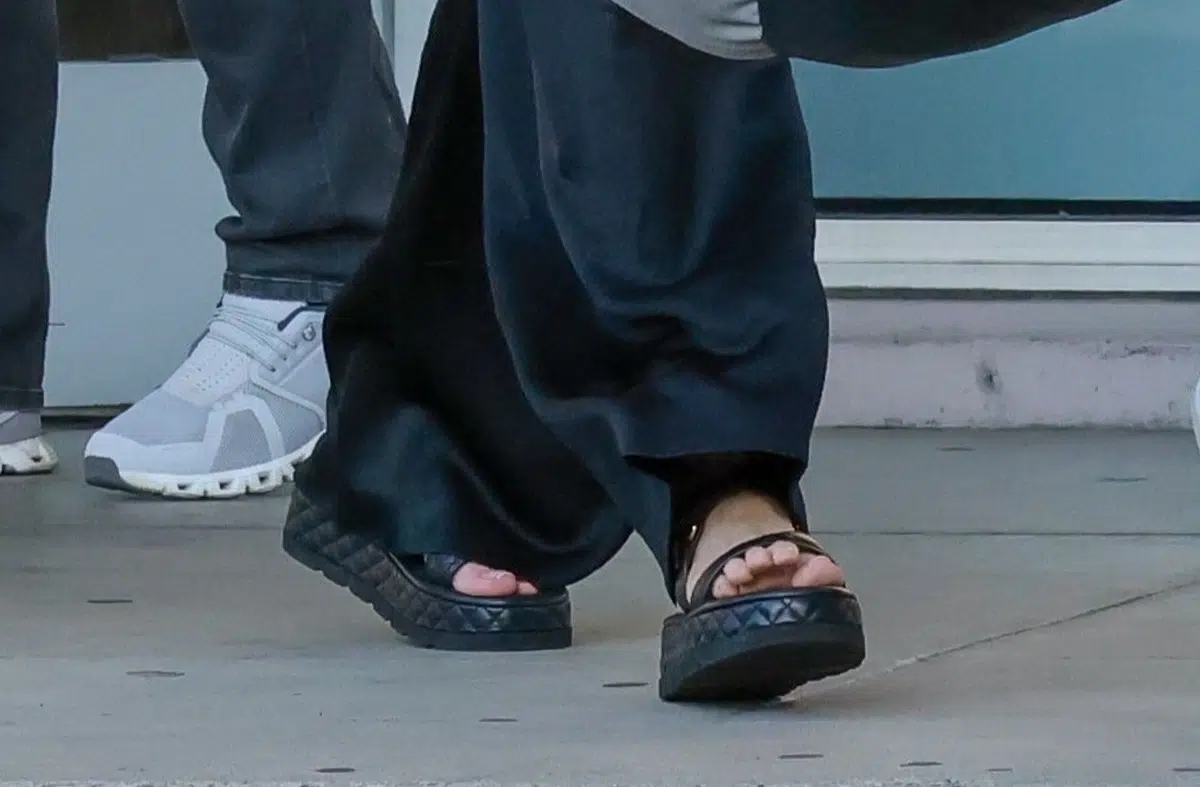 Анджелина Джоли в черных брюках и модных сандалиях на высокой подошве