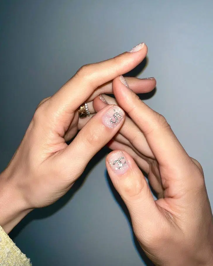 Блестящий маникюр со стразами на коротких ногтях с логотипом Chanel