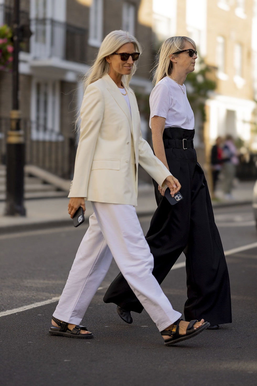 Женщина в простых белых брюках, пиджаке молочного цвета и сандалиях на липучках