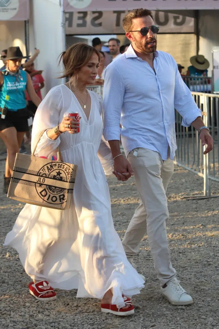 Дженнифер Лопес в легком белом платье, бежевой сумкой и небрежным пучком на голове