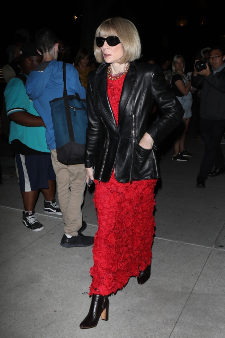 Анна Винтур в красном платье из раз, черных сапогах и кожаной куртке