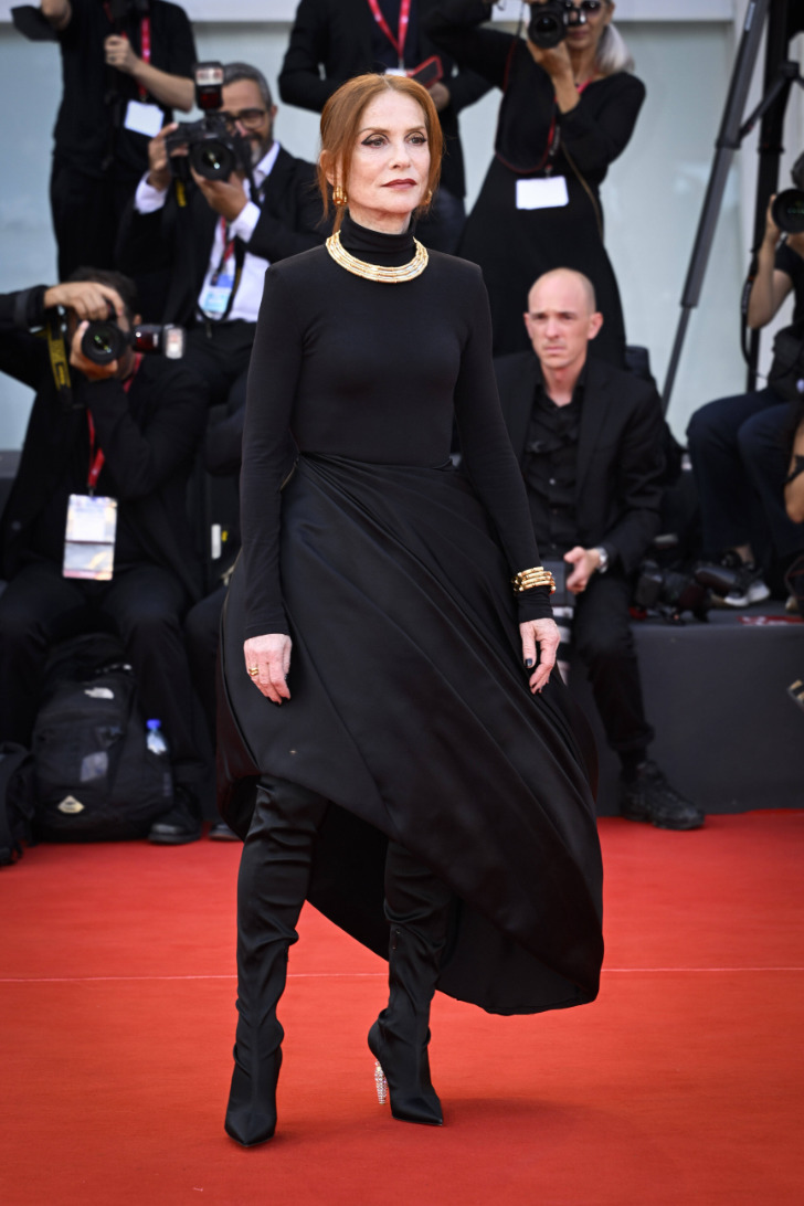 Изабель Юппер в черном авангардном платье, ботфортах и золотых украшениях
