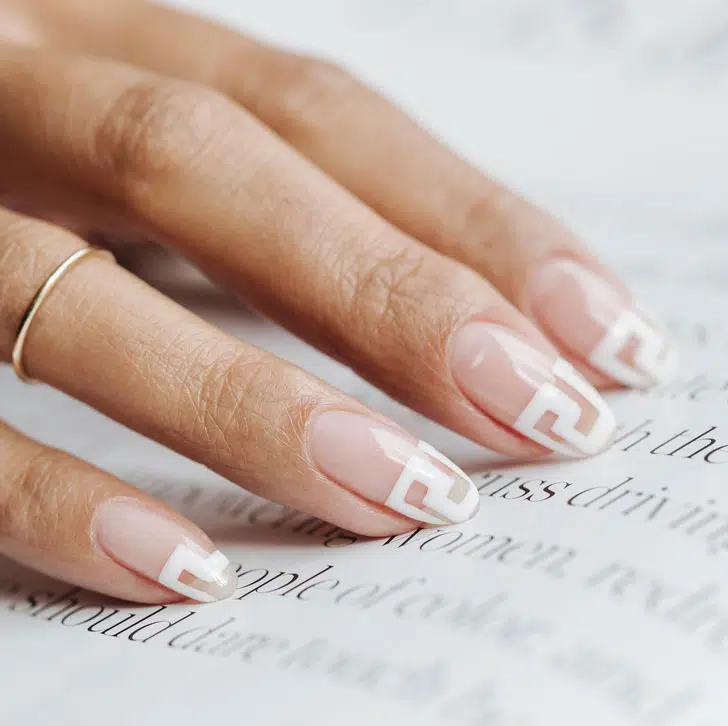 Натуральный маникюр с белым узором в стиле Versace на овальных ногтях средней длины