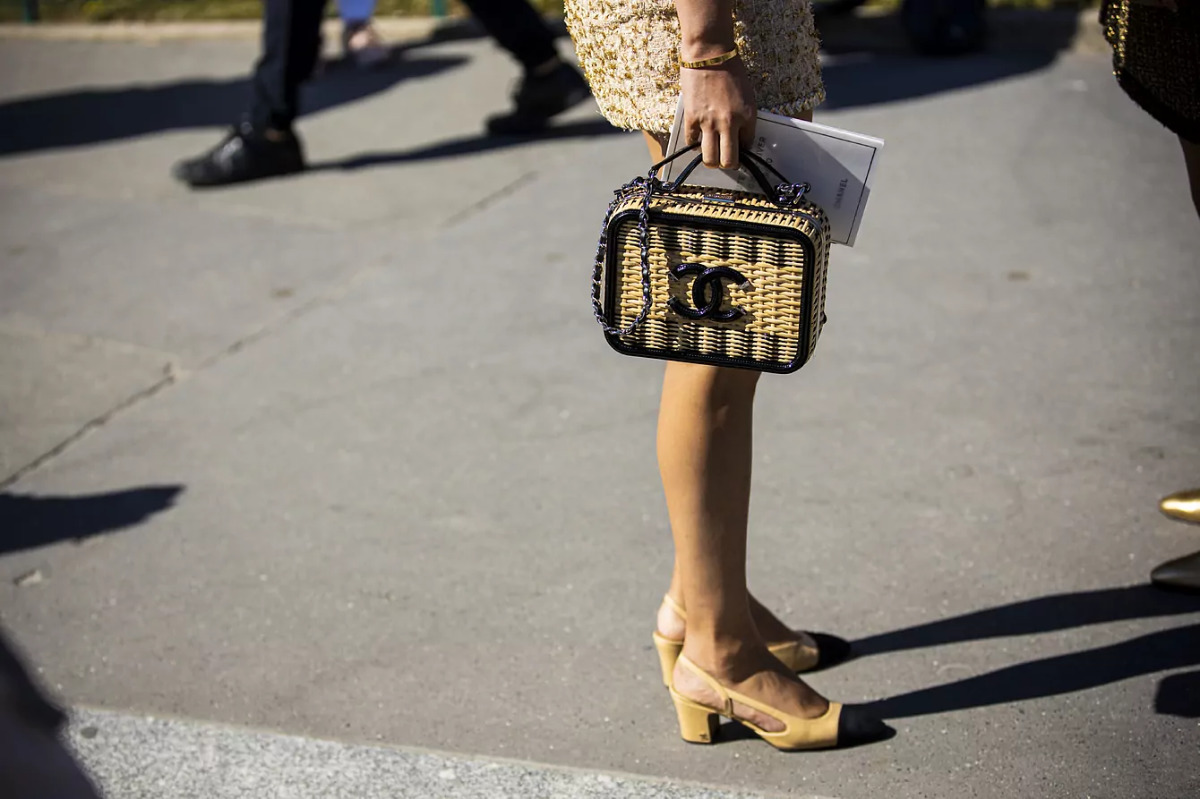 Девушка в двухцветных туфлях на низком каблуке и с небольшой сумочкой от Chanel
