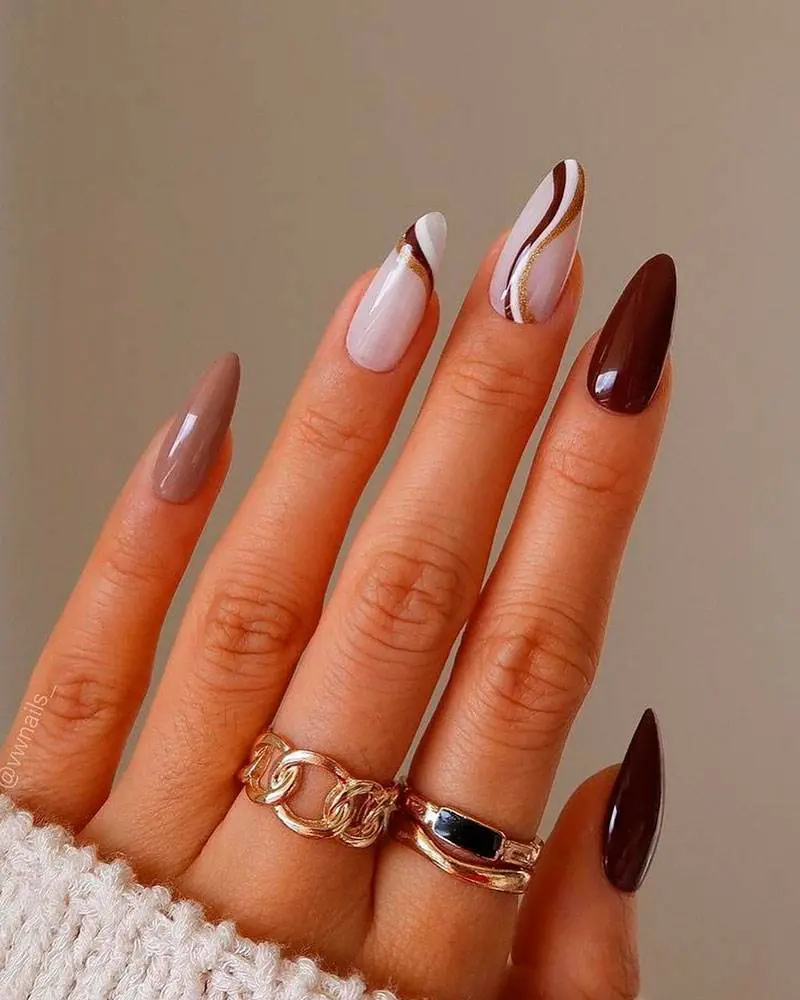 Осенний маникюр с коричневыми завитками на длинных миндальных ногтях
