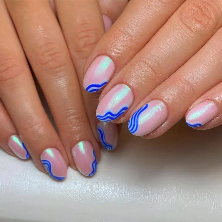 Розовый жемчужный маникюр с синими волнами на овальных ногтях