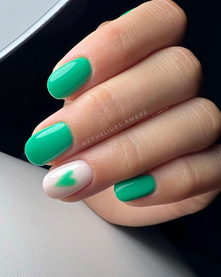 Зеленый маникюр с сердечком на овальных ногтях средней длины