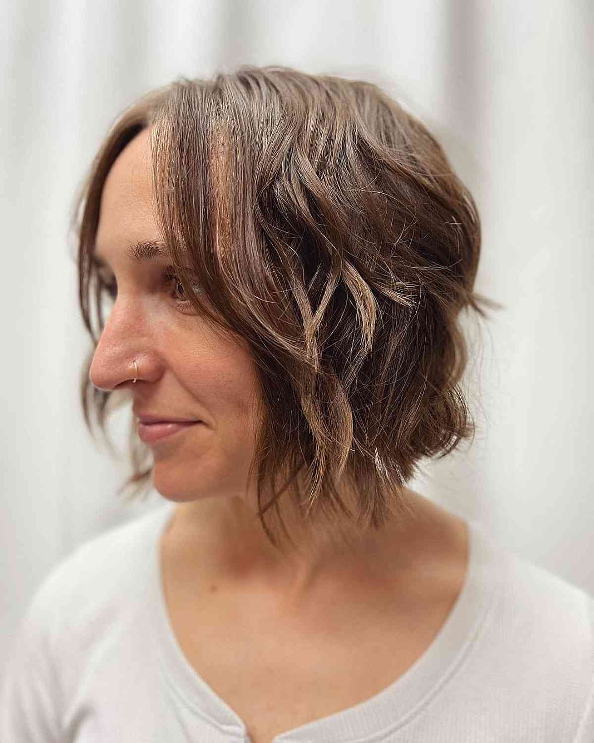 Женщина с короткой волнистой стрижкой на тонких натуральных волосах