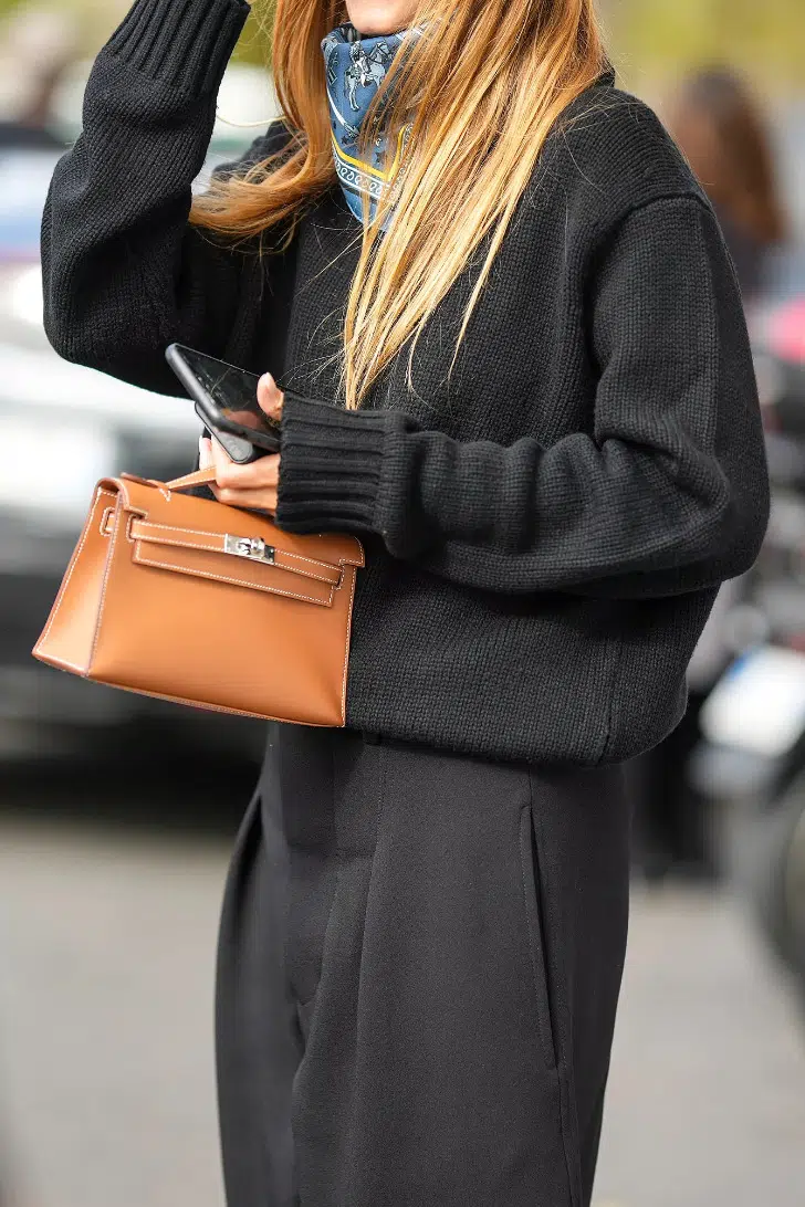 Девушка в черных брюках со складками и классическом свитере
