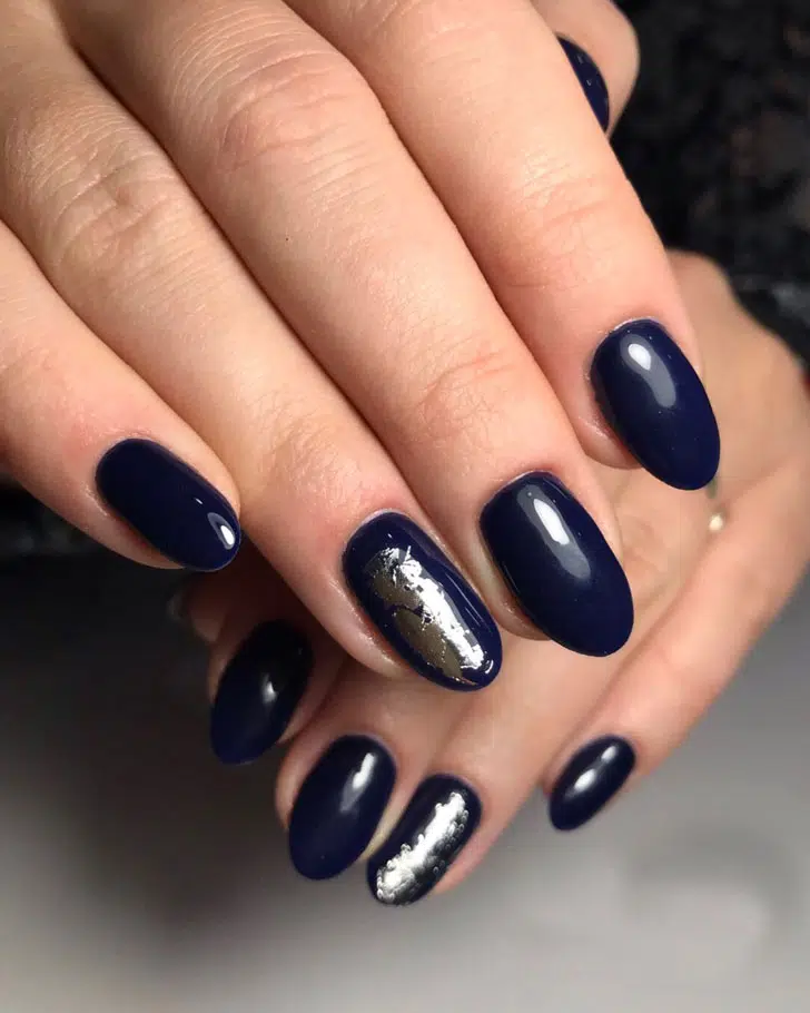 Глубокий синий маникюр с серебристой фольгой на овальных ногтях средней длины
