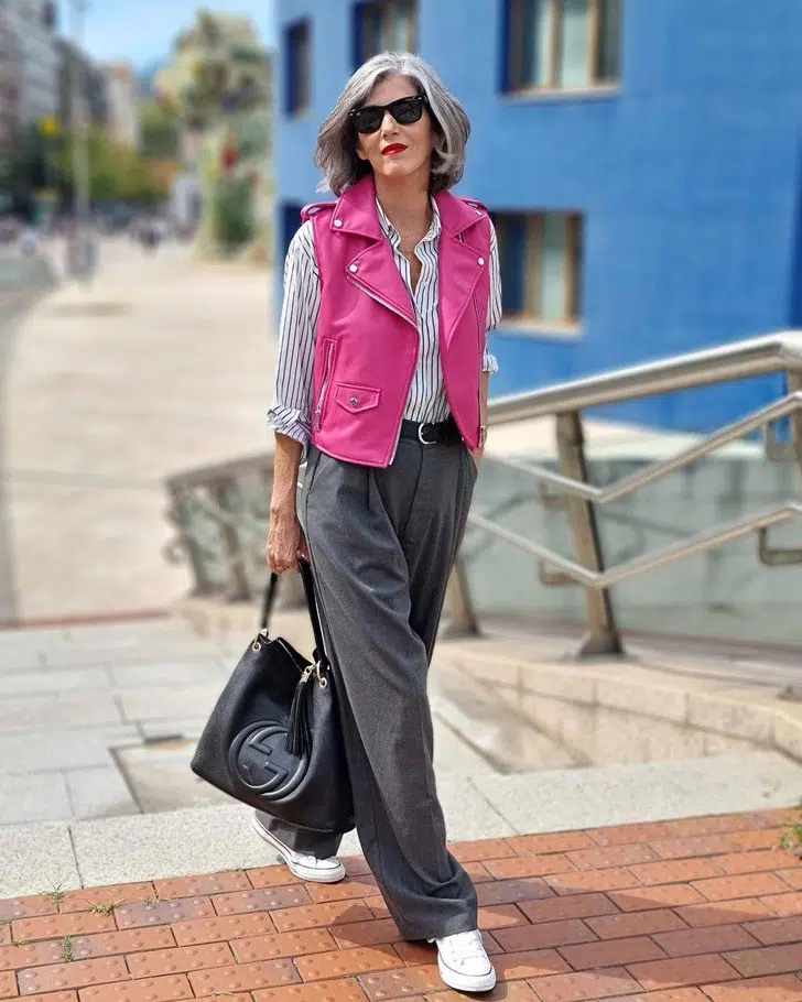Кармен Гимено в свободных серых брюках, рубашке в полоску и розовом жилете