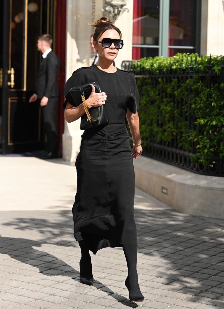 Виктория Бекхэм в черном платье миди с необычными складками и сумкой