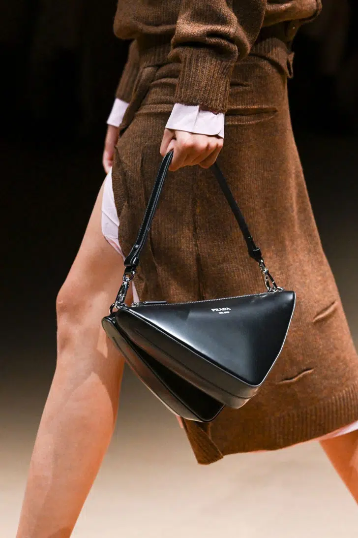Модель с черной треугольной сумкой от Prada