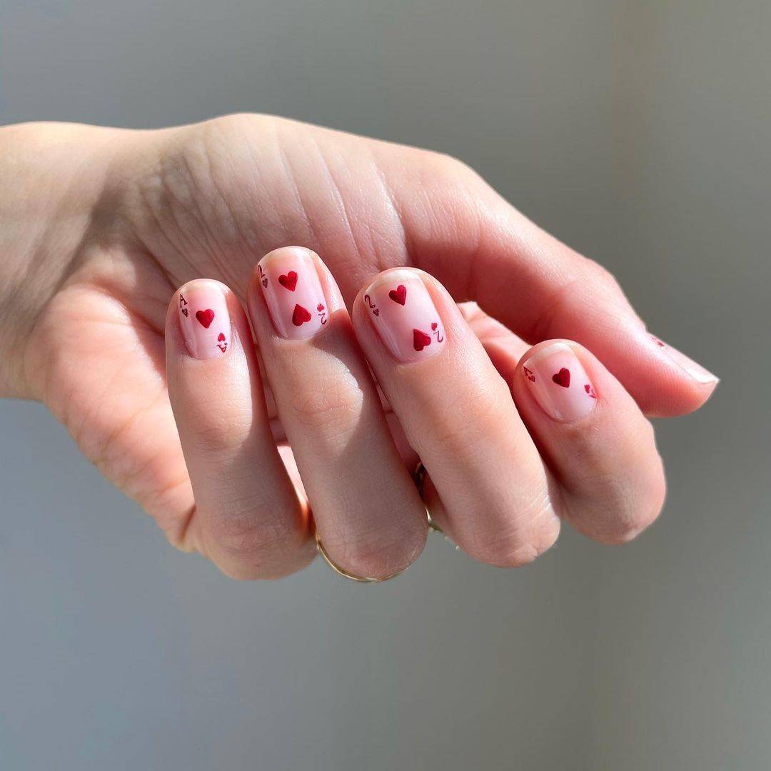 Нейтральный маникюр с красным принтом карт на коротких квадратных ногтях