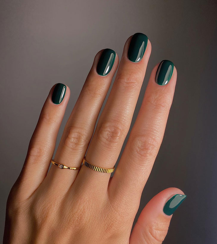 Темно зеленый маникюр на ухоженных натуральных ногтях средней длины