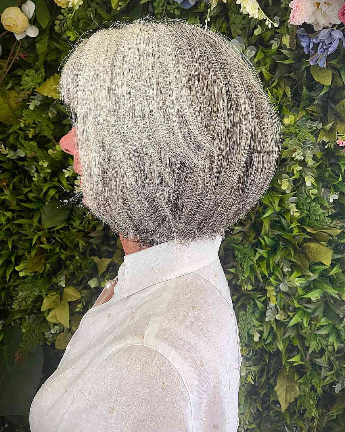 Женщина с многослойной стрижкой боб с челкой на седых волосах