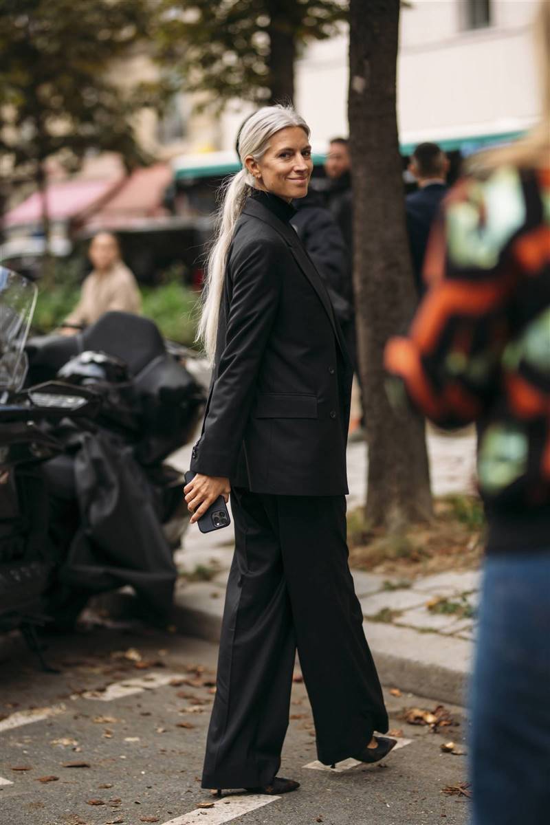Женщина в черном костюме оверсайз и классических туфлях лодочках