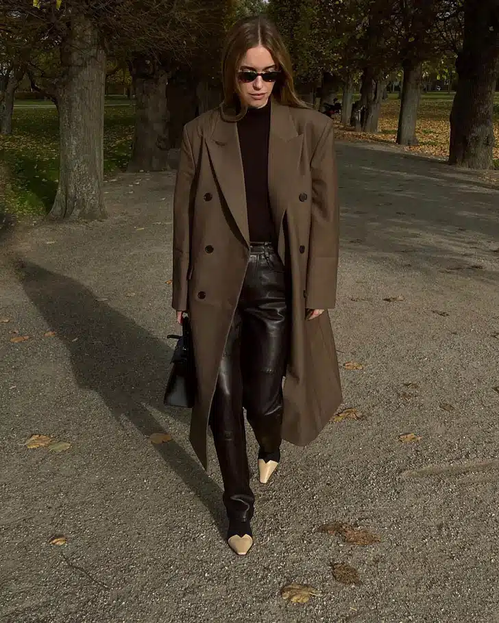 Пернилль Тейсбек в коричневом пальто, кожаных брюках и двухцветных ботильонах