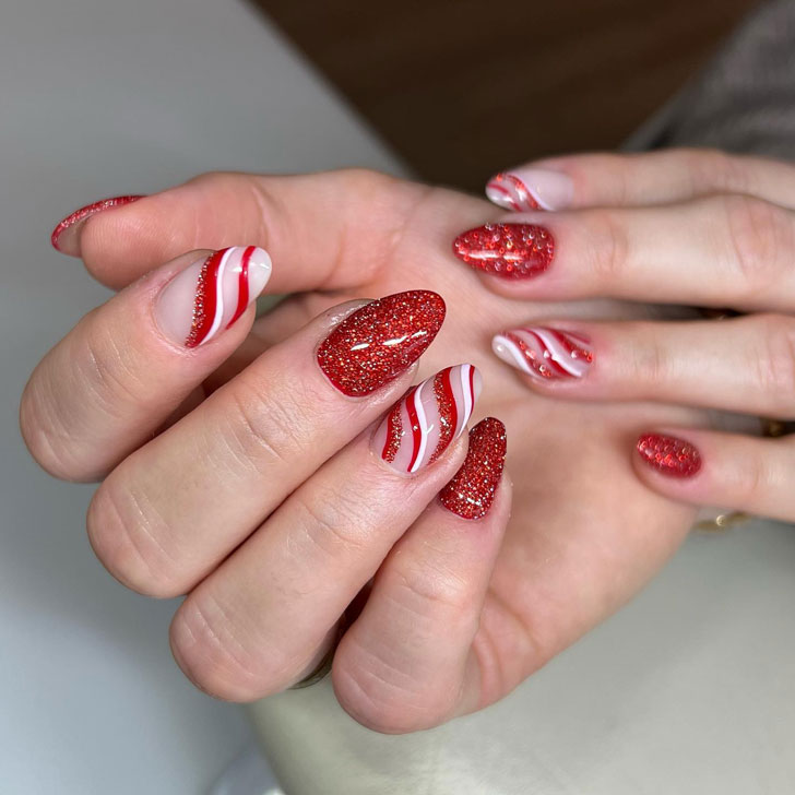 Новогодний красный маникюр с завитками и блестками на миндальных ногтях