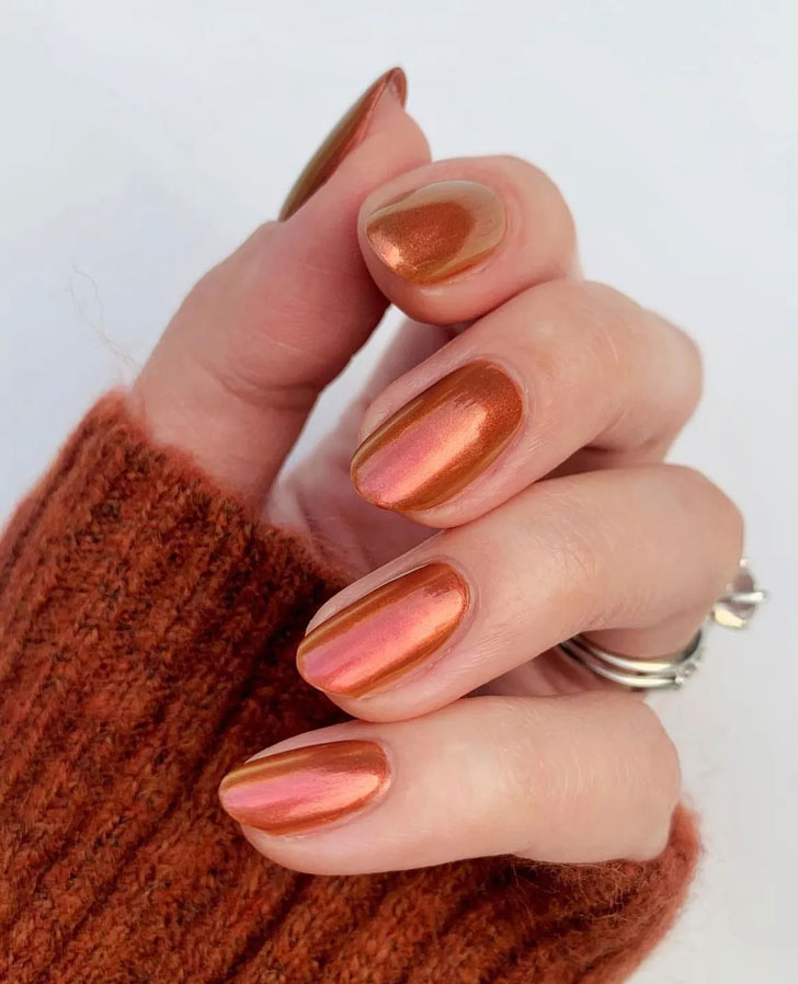Оранжевый металлизированный маникюр на овальных ногтях средней длины