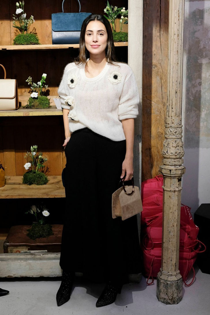 Алессандра де Осма в длинной черной юбке, свитере молочного цвета и черных ботильонах