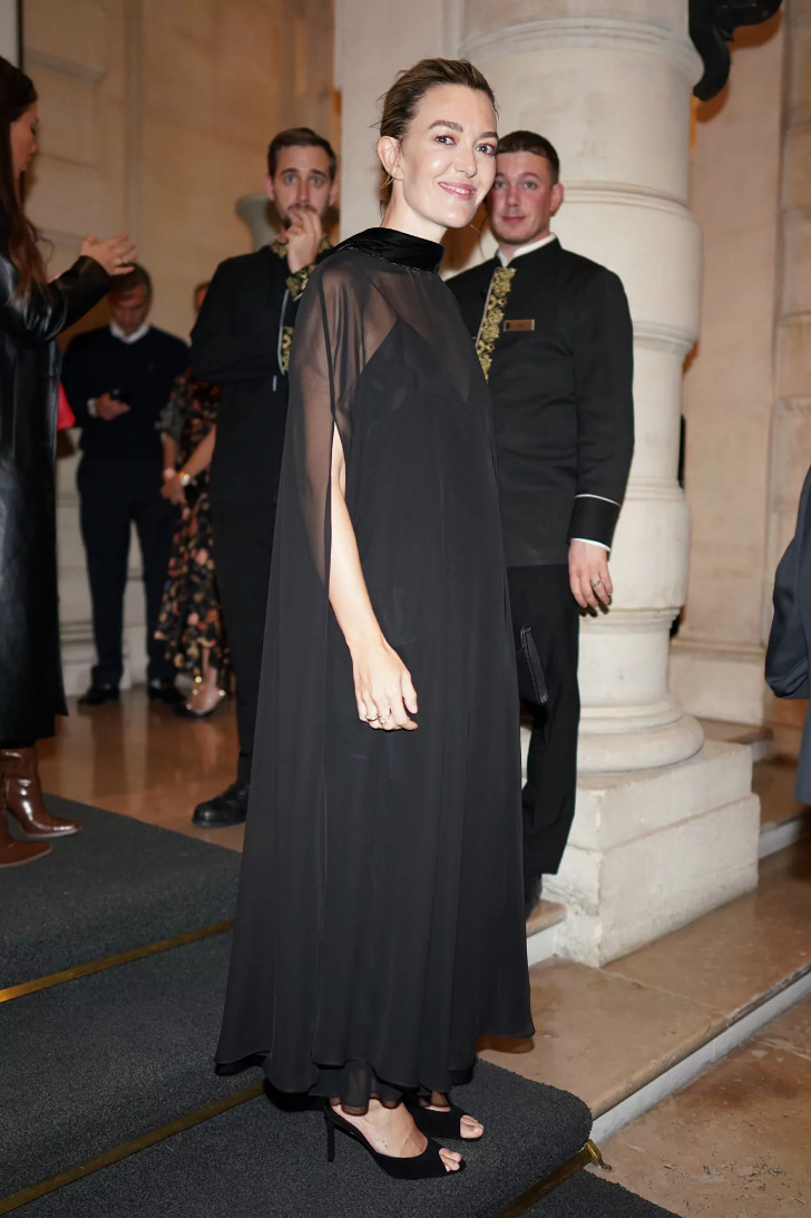 Марта Ортега в черном платье, длинной прозрачной накидке и туфлях с открытыми пальчиками