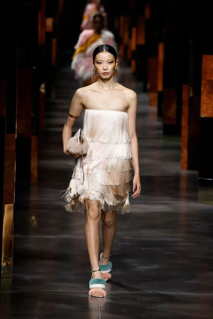 Модель в бежевом вечернем платье с бахромой и открытыми плечами от Fendi