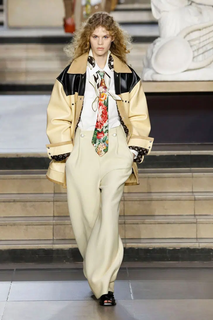 Модель в бежевых широких брюках и куртке оверсайз от Louis Vuitton