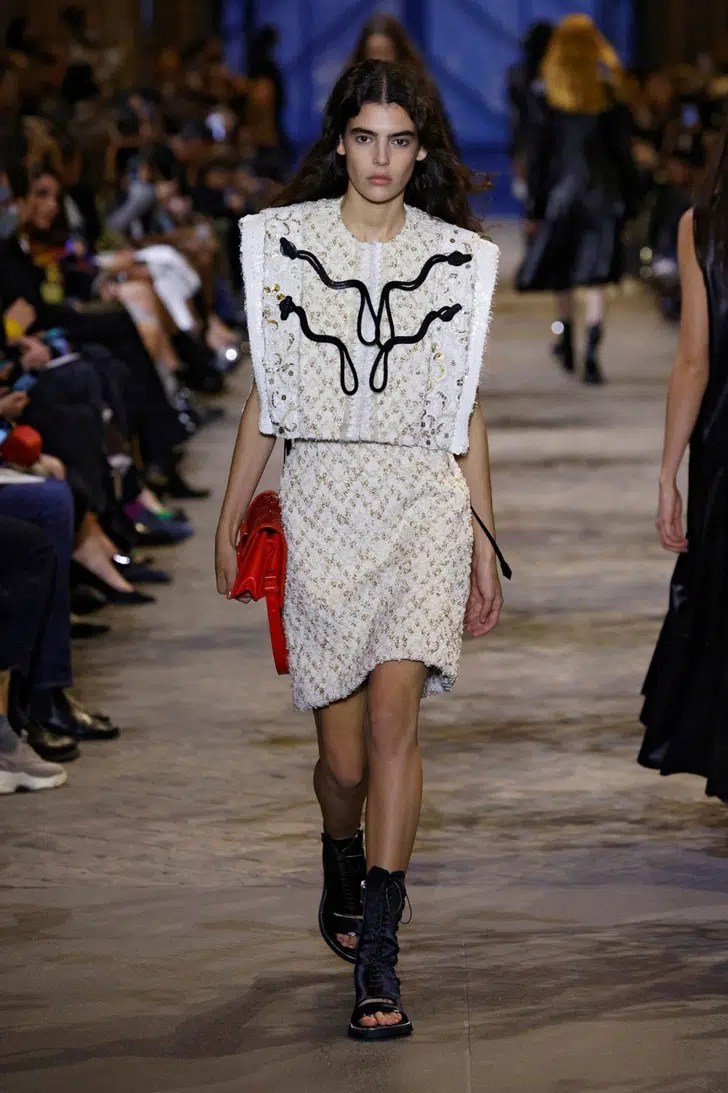Модель в романтичном бежевом костюме с мини юбкой от Louis Vuitton
