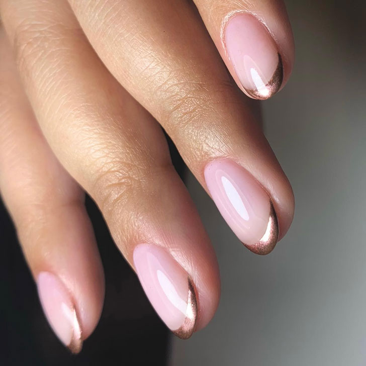 Rose gold metallic french manicure on manicured oval nails
