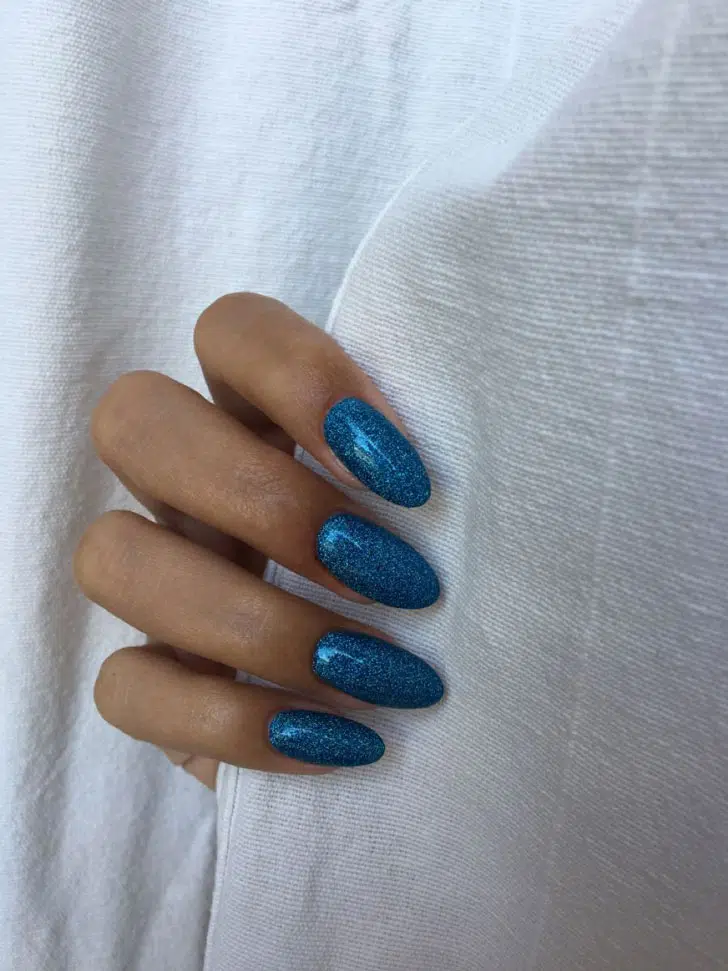 Синий маникюр с блестками на длинных овальных ногтях