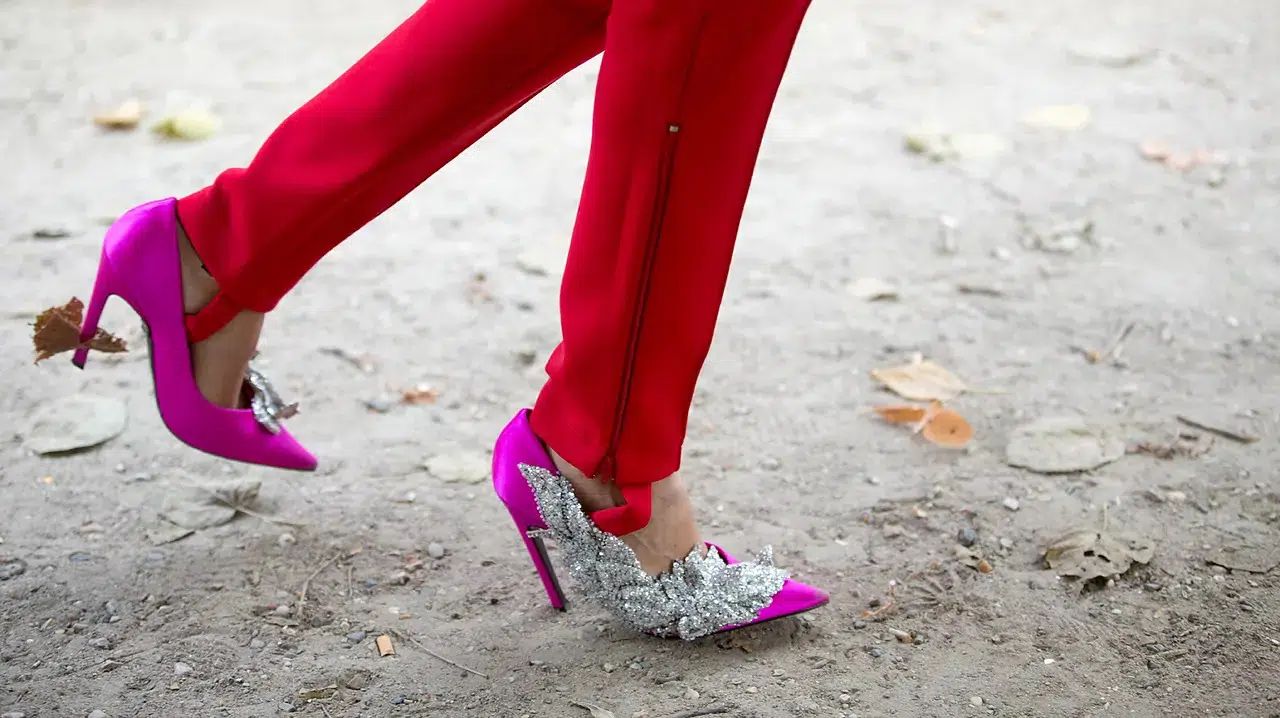 Девушка в красных брюках и туфлях цвета фуксии с серебристыми украшениями