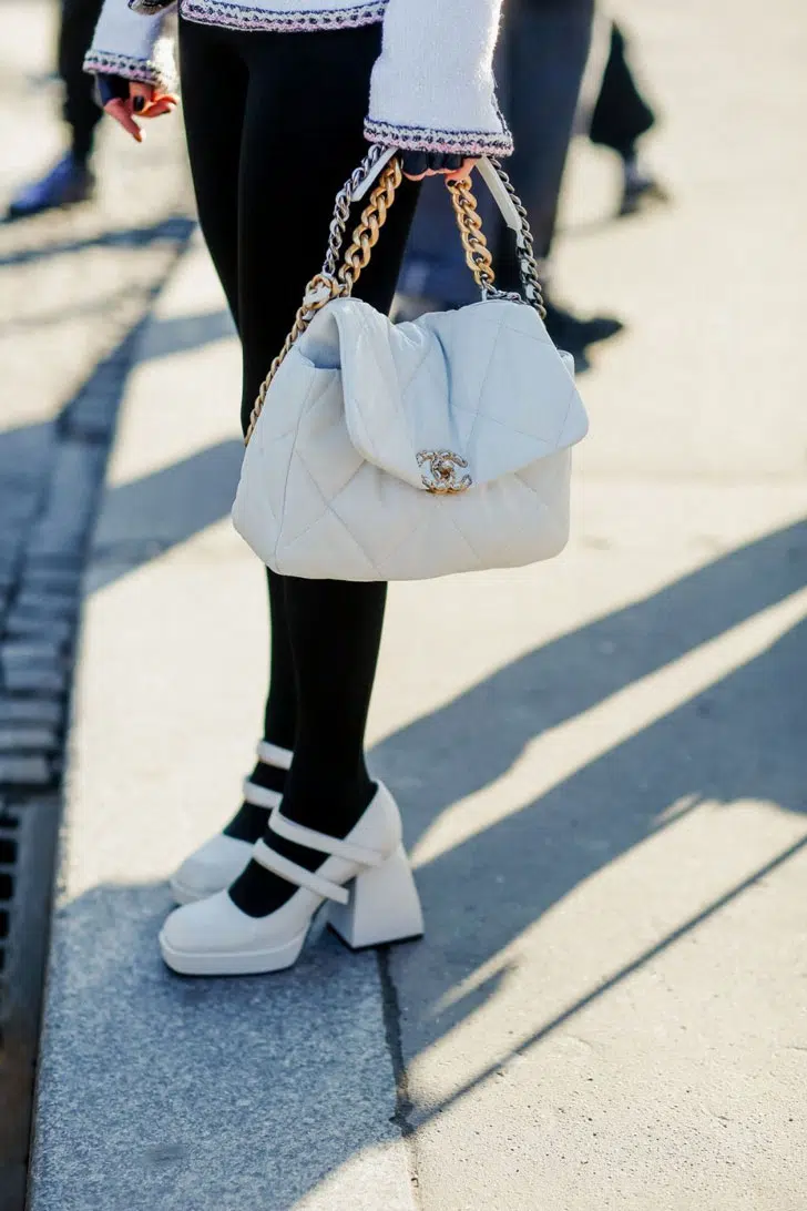 Девушка в белых туфлях с ремешками и толстым блочным каблуком