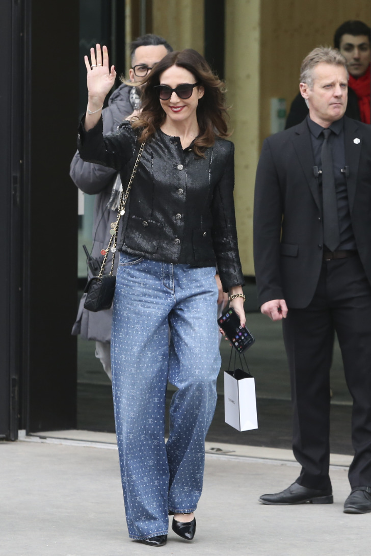 Девушка в широких джинсах и черном строгом жакете перед показом Chanel 2023