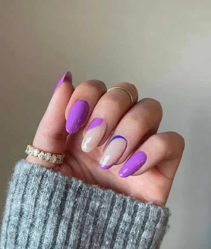 Яркий фиолетовый маникюр с синим акцентом на ухоженных овальных ногтях