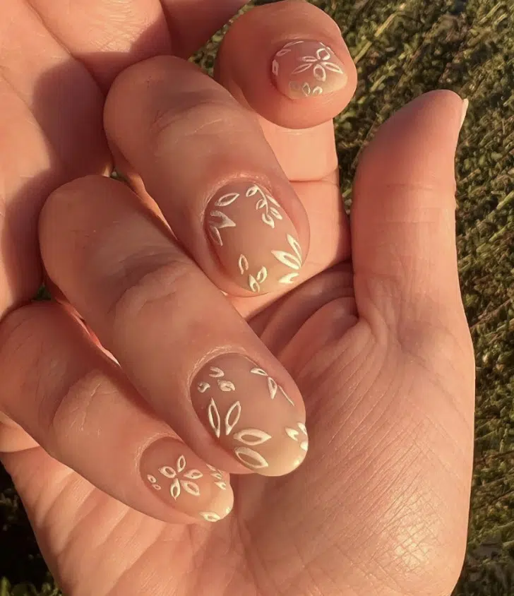 Бежевый маникюр с белыми простыми цветами в стиле бохо на овальных ногтях