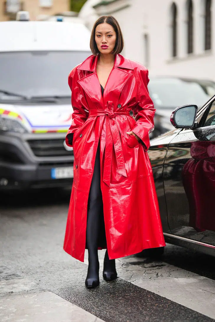 Девушка в красном кожаном пальто с поясом и черных ботильонах