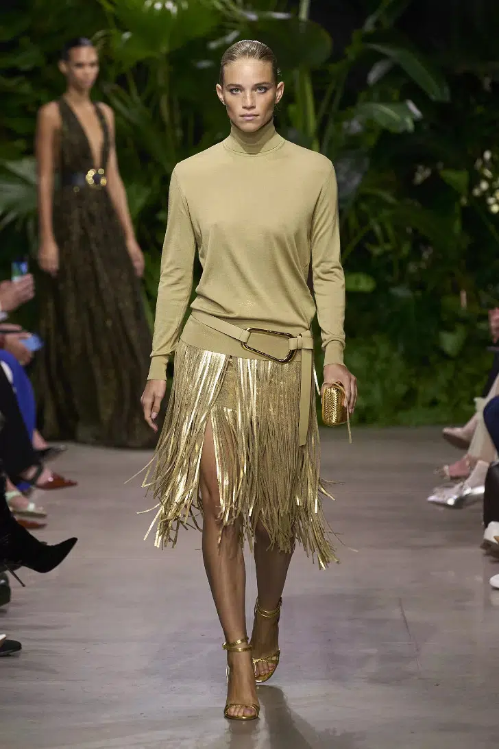 Девушка в золотистой юбке с перьями и водолазке