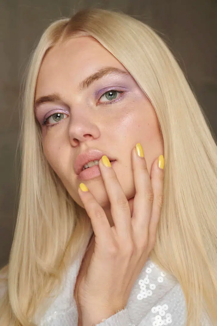 Девушка с желтым пастельным маникюром на коротких натуральных ногтях