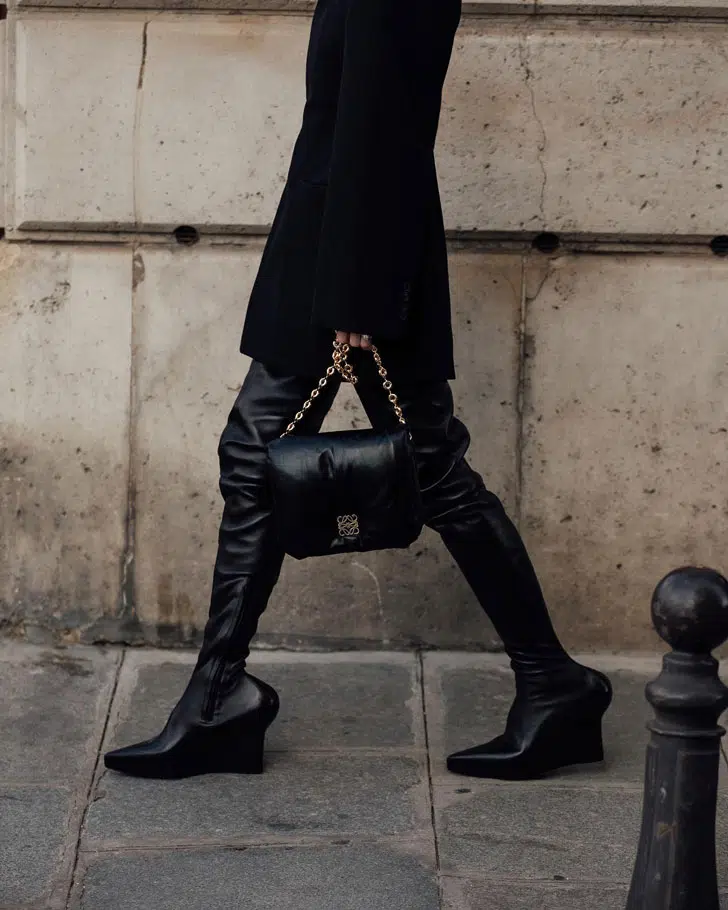 Девушка в черных сапогах с комфортным каблуком набирающем популярность среди модниц