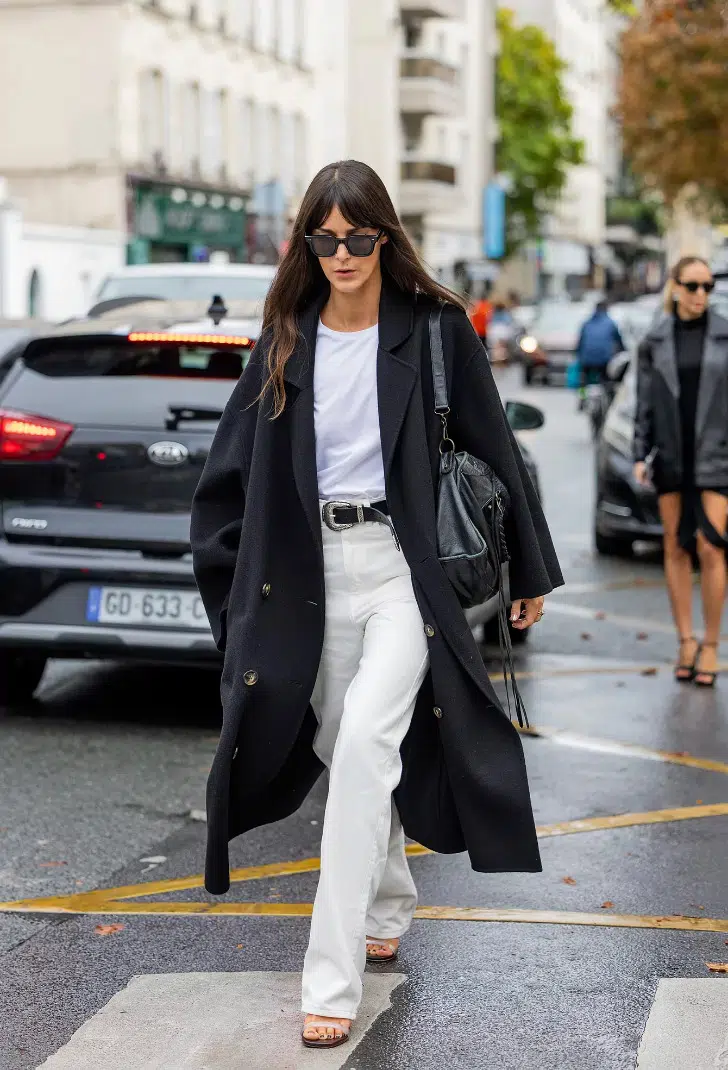 Лея Сфез белых джинсах с ремнем, майке и темном пальто оверсайз