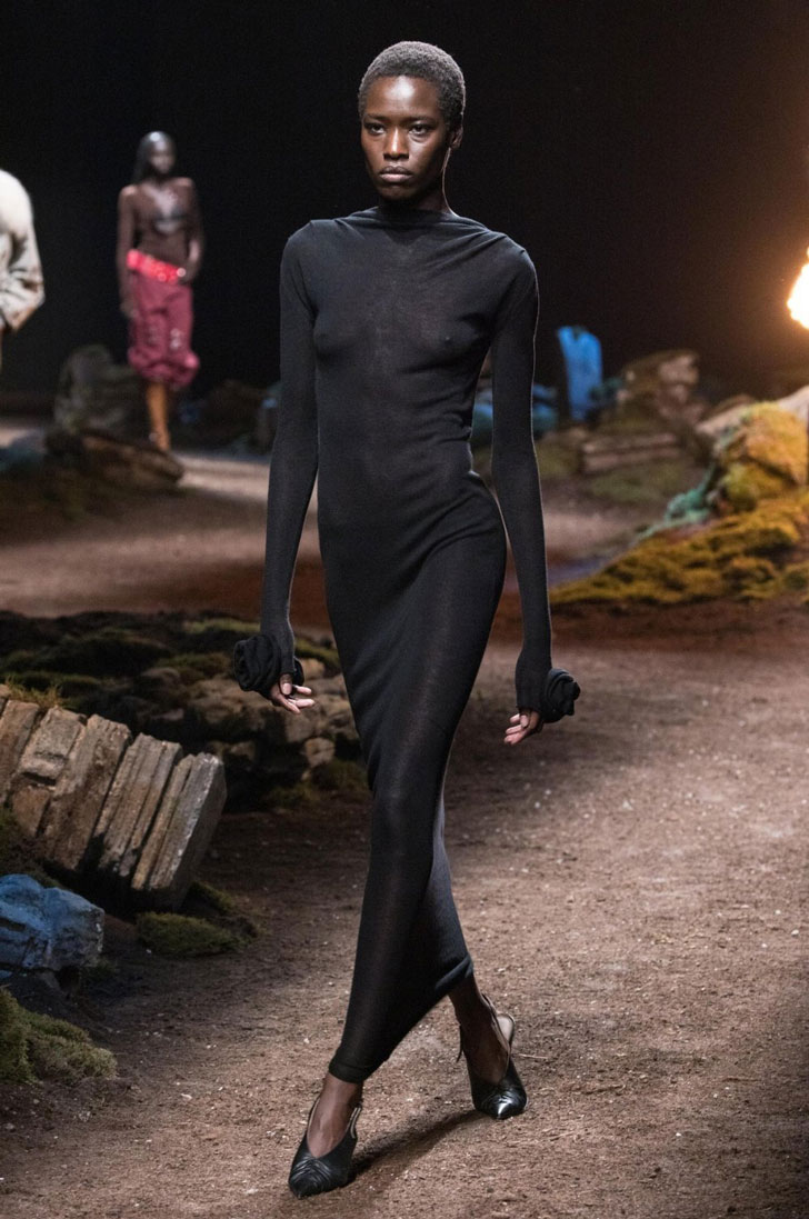 Модель в черном облегающем платье и сабо на полном каблуке