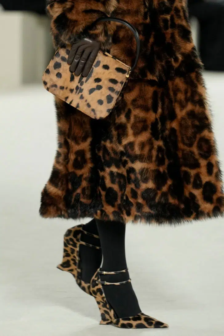 Модель в леопардовой шубе и леопардовых туфлях с ремешками и полным каблуком