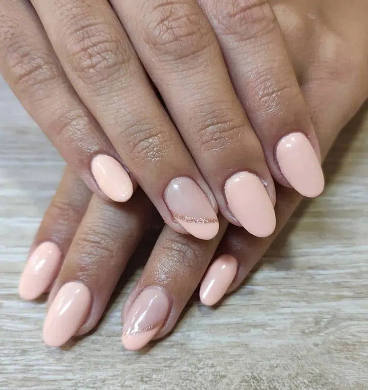 Нежно розовый маникюр с золотой линией на овальных ногтях средней длины
