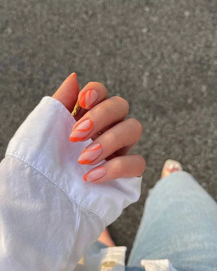 Оранжевый волновой маникюр на овальных ногтях средней длины