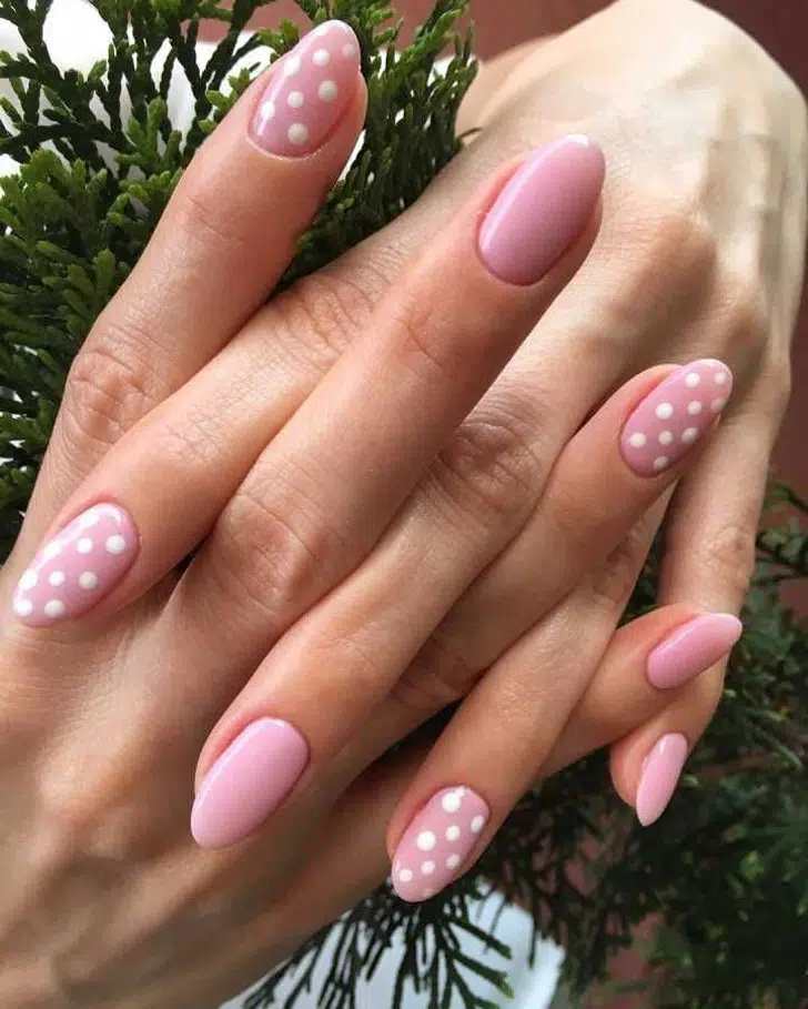 Розовый маникюр с белыми точками на овальных ногтях средней длины