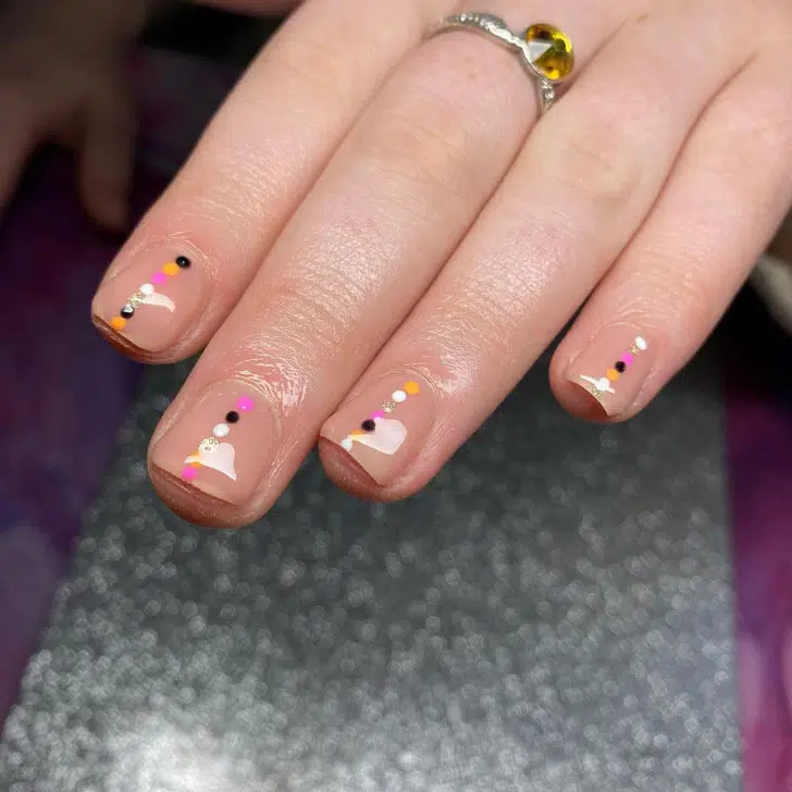 Бежевый маникюр с полосой разноцветных точек на коротких ногтях