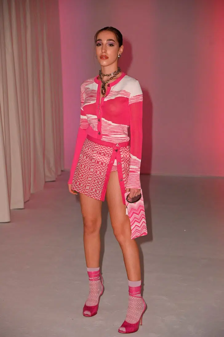 Девушка в мини юбке, бело-розовой кофточке и розовых босоножках с носками