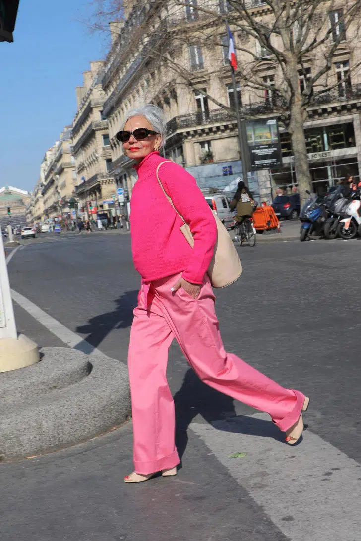 Грес Ганем в розовых широких брюках, свитере цвета фуксии и босоножках