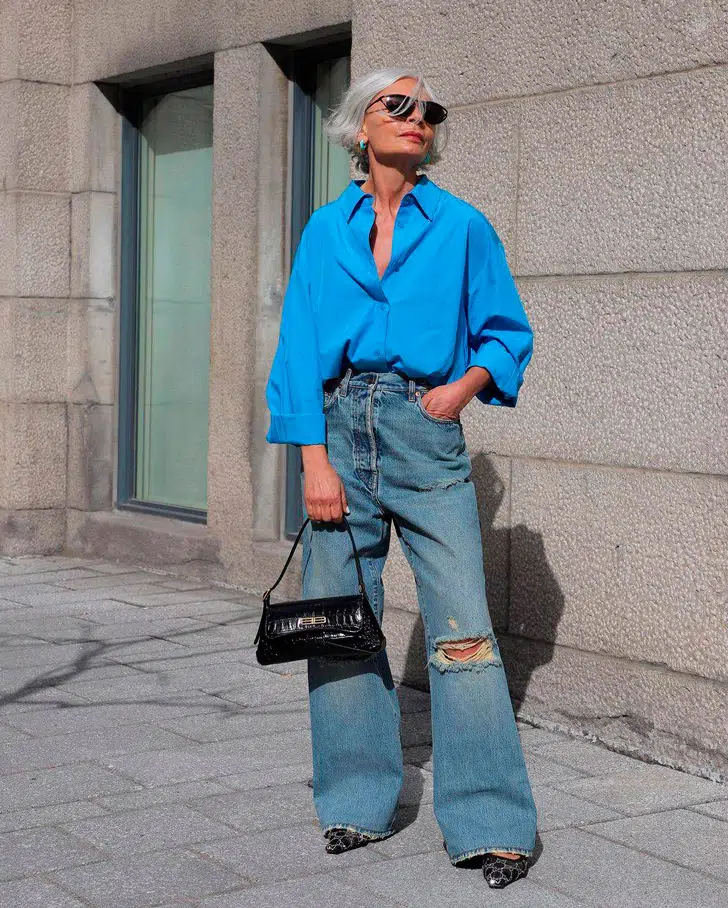 Грес Ганем в широких рванных джинсах, синей рубашке оверсайз и туфлях